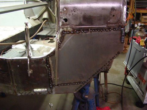 1948 Jeep Wrangler - Metal body panel is being welded onto a vehicle chassis during a repair process.
