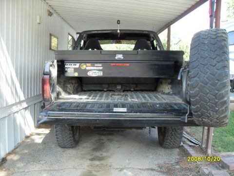 1990 Ford Bronco - Rear view of a 1990 Ford Bronco showing the tailgate, spare tire, and toolbox.