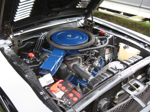 1968 Shelby GT500 - The engine compartment of a classic car, a prominent blue air filter assembly and battery.