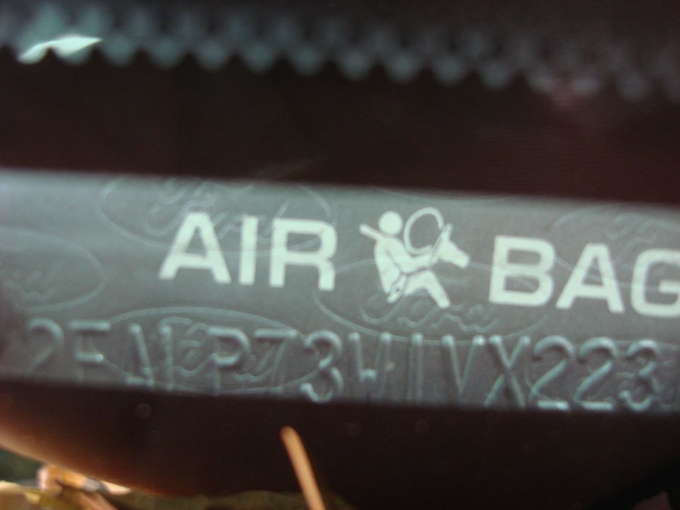 Close-up of an airbag warning label with text and a symbol