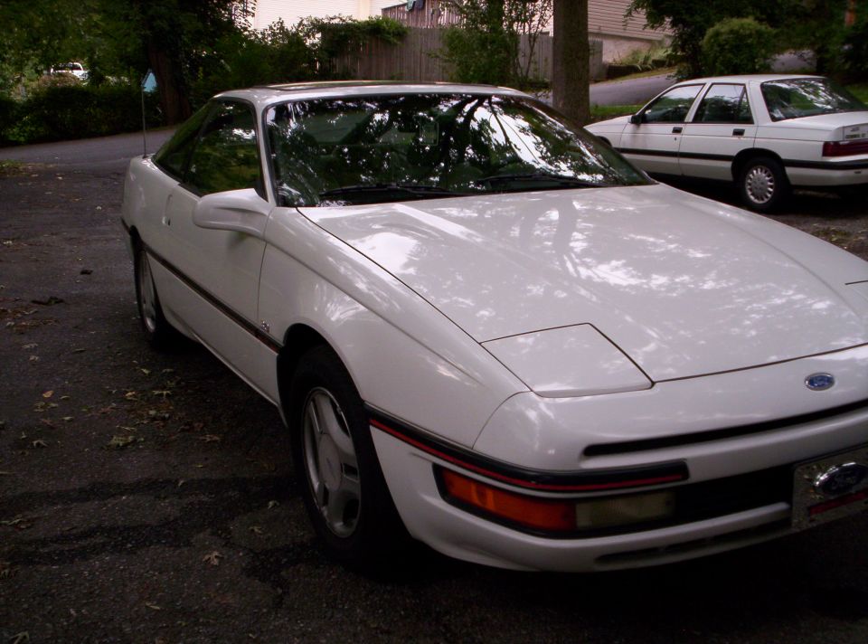 White Ford Probe coupe, 3/4 front view parked on asphalt