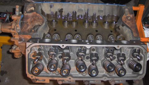 1978 Ford Bronco - Close-up view of an engine's internal components, including the cylinder heads and valve train, with visible oil.