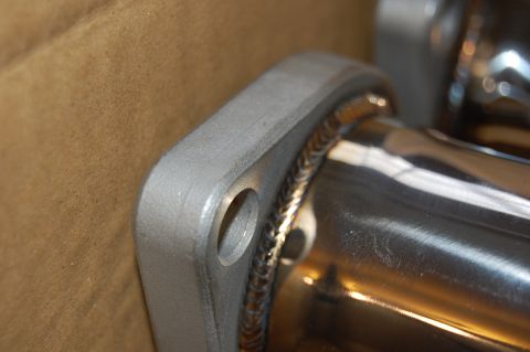 2002 BMW M3 - Close-up of a metal exhaust pipe flange, showing weld details and bolt holes.