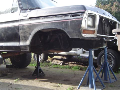 1979 Ford Bronco - This Ford truck is raised on jack stands, showing its undercarriage and missing front grille.