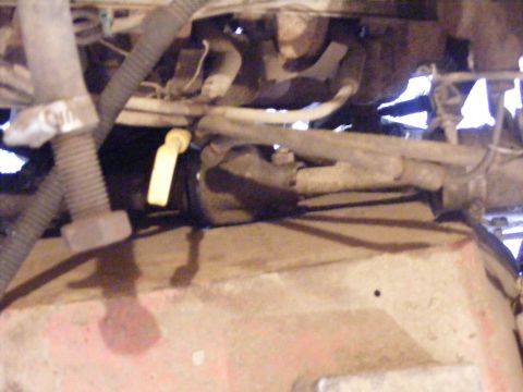 1974 Ford Bronco - Close-up view of an engine bay, showing various hoses and a yellow dipstick.