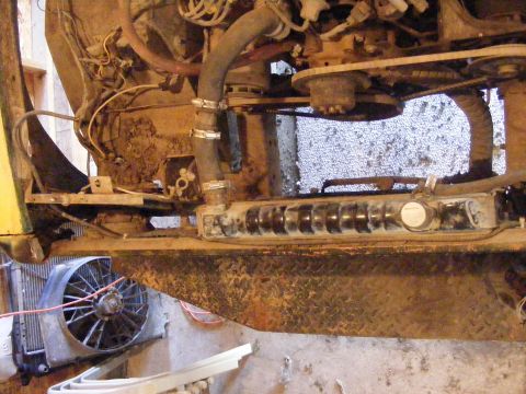 1974 Ford Bronco - Close-up of engine components including radiator, fan, and hoses, with visible wear and tear.
