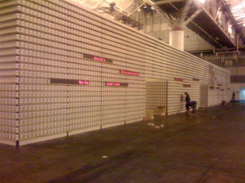 1994 Ford Bronco - A large display of cans is set up in a warehouse, with several people visible working.