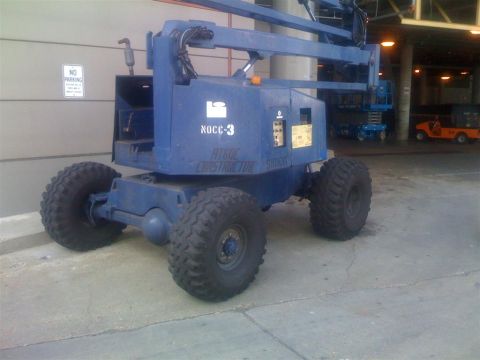 1994 Ford Bronco - Blue Nocc-3 Constructor lift with large off-road tires parked outdoors.
