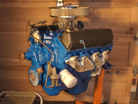1978 Ford Bronco - A blue V8 engine with a chrome air cleaner and oil filter is mounted on an orange engine stand.