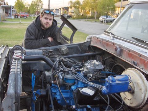 1978 Ford Bronco - A man poses with the engine of a vehicle, which is partially disassembled.