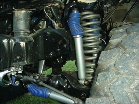 1987 Ford Bronco - Suspension parts and tire detail from a vehicle.