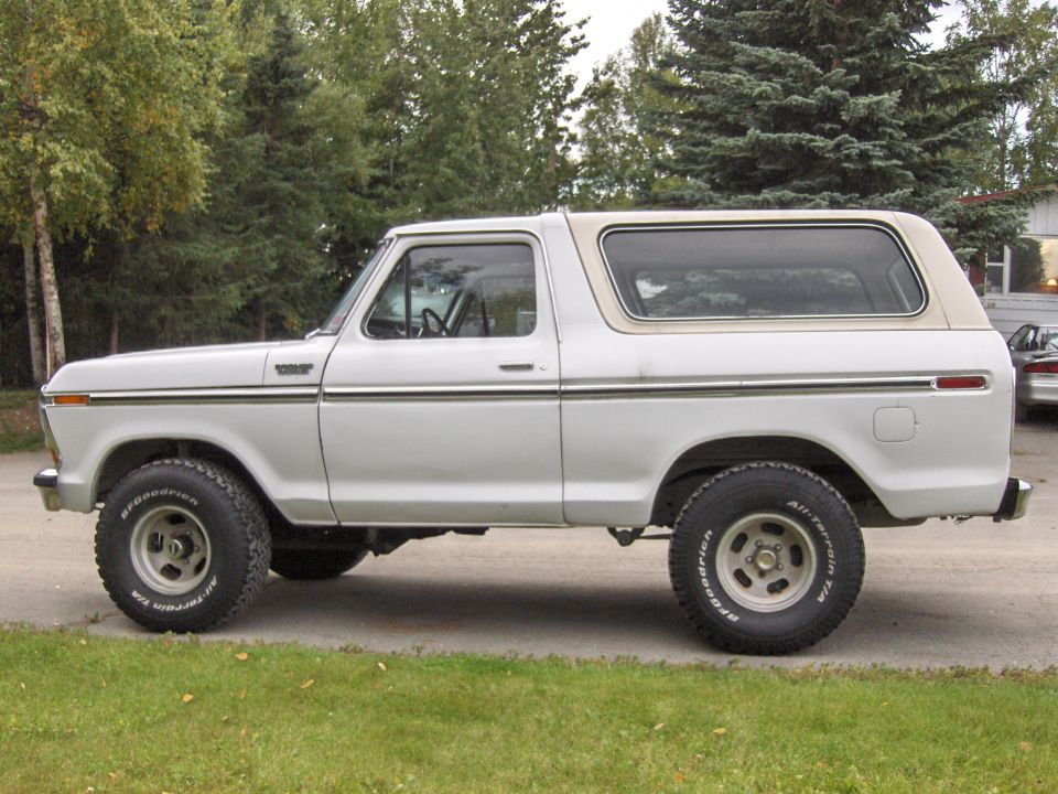 Side view of a white late-1970s Ford Bronco with cream hardtop and BFGoodrich all-terrain tires