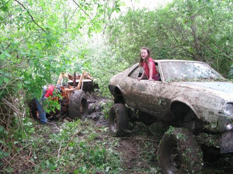 1978 AMC Javelin - A girl looks out the window of a mud-caked car while a tractor is stuck in the muck behind it.