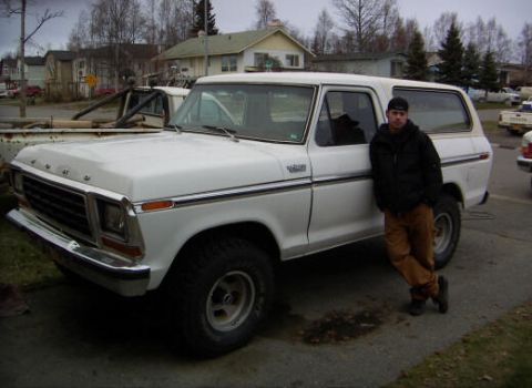 1978 Ford Bronco - A white 1978 Ford Bronco is parked outside with a man leaning against it.