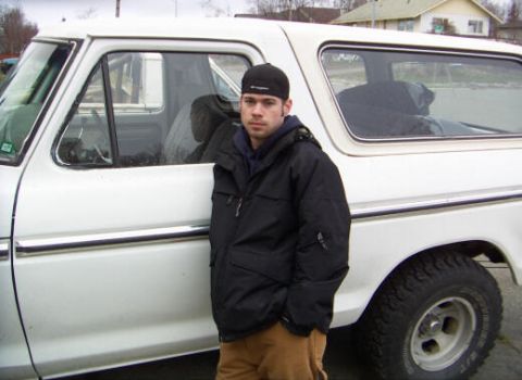 1978 Ford Bronco - A man stands next to a white 1978 Ford Bronco, showing its side profile.