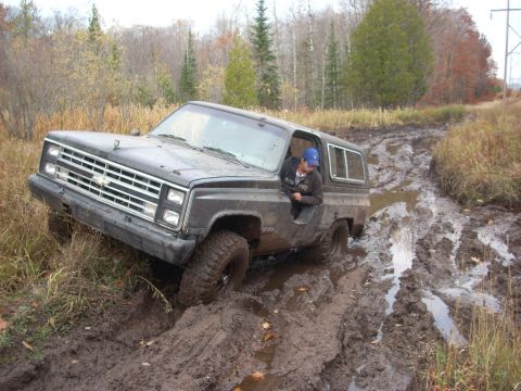 1988 Chevrolet Blazer - A 1988 Chevrolet Blazer navigates a treacherous muddy trail, with the driver looking out the window.