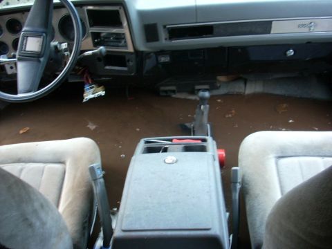 1988 Chevrolet Blazer - The interior of the vehicle shows significant water damage, with the floor covered in mud and debris.
