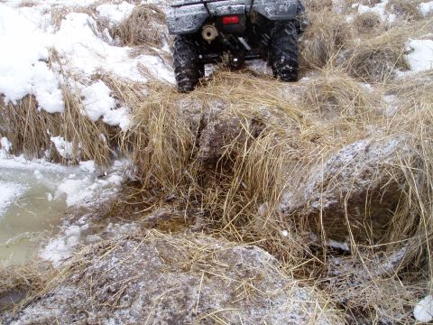 2000 Ford E350 - An ATV navigates a snowy, grassy area with icy water visible.