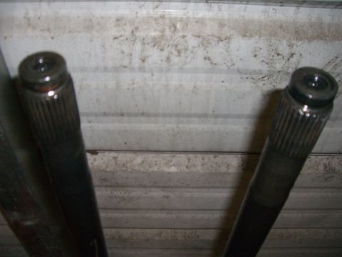 1988 Ford Bronco - Two vehicle axle shafts are shown against a corrugated metal background.