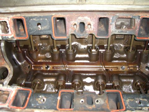 1988 Ford Bronco - This is a close-up view of an engine's intake manifold, showing the pushrods and gasket surfaces.