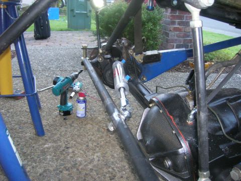 1996 Ford Bronco - Close-up of vehicle suspension components and tools on a paved surface.