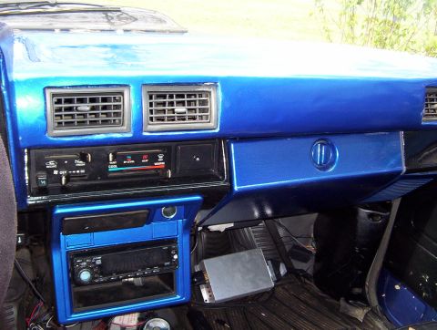 1986 Toyota Hilux - The interior features a custom blue dashboard with dual air vents, an aftermarket stereo, and various controls.