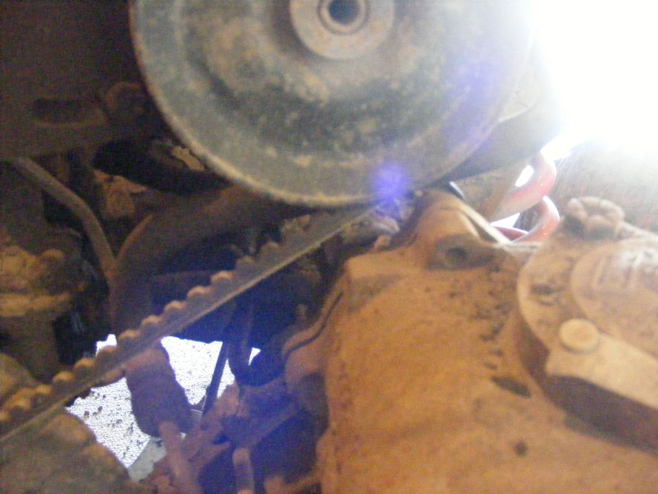 Close-up of a ribbed belt on a pulley, part of a vehicle's engine