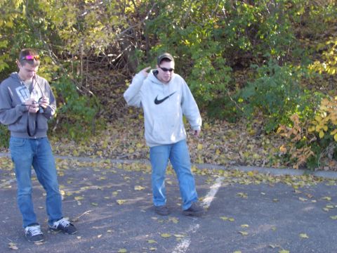 1991 Ford Probe - Two men are standing in a parking lot with trees and fallen leaves in the background.