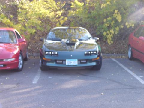 1991 Ford Probe - A green 1991 Ford Probe is parked next to a red car.