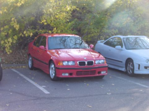 1991 Ford Probe - Two cars, a red BMW sedan and a white Acura coupe, are parked in an outdoor lot.