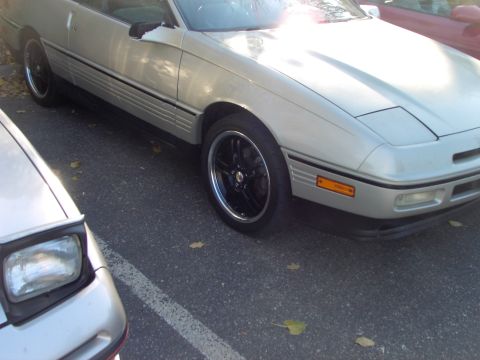 1991 Ford Probe - Silver 1991 Ford Probe with aftermarket black wheels parked in a lot.