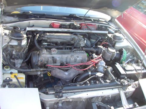 1991 Ford Probe - The engine bay of a car is shown with various components and wiring visible, along with a watermark from Supermotors.net.