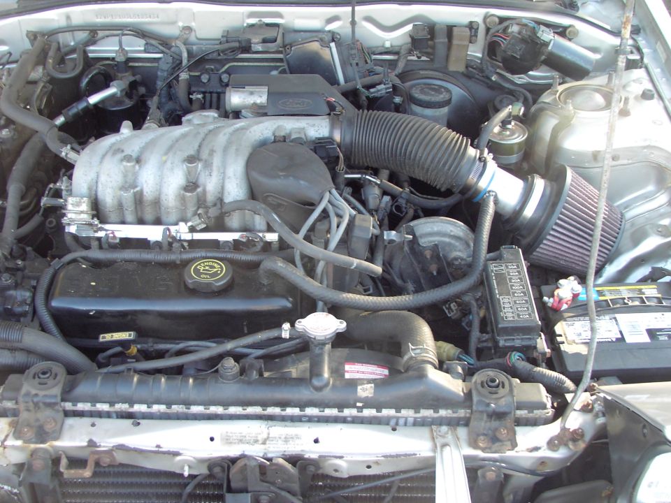 Engine bay with V6 intake manifold, air filter, fuse box, and radiator