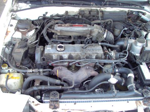 1991 Ford Probe - The engine bay of a 1991 Ford Probe reveals its 2.2L turbo engine, complete with hoses, wiring, and radiator.