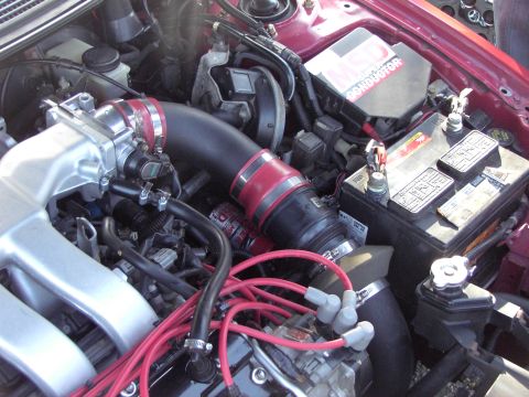 1991 Ford Probe - Close-up view of the engine bay in a 1991 Ford Probe, showing the intake manifold, battery, and ignition system.