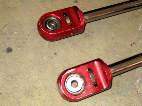 1996 Ford Bronco - Close-up of two red suspension components with visible ball joint assemblies.