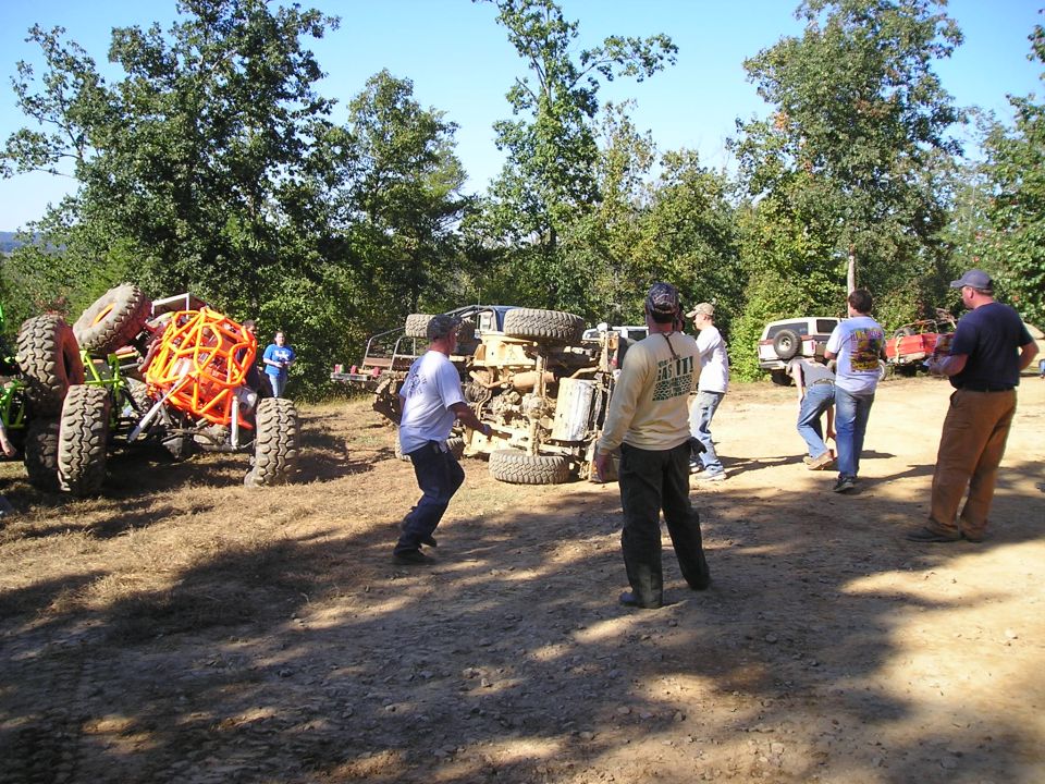Overturned off-road vehicle with people gathered around