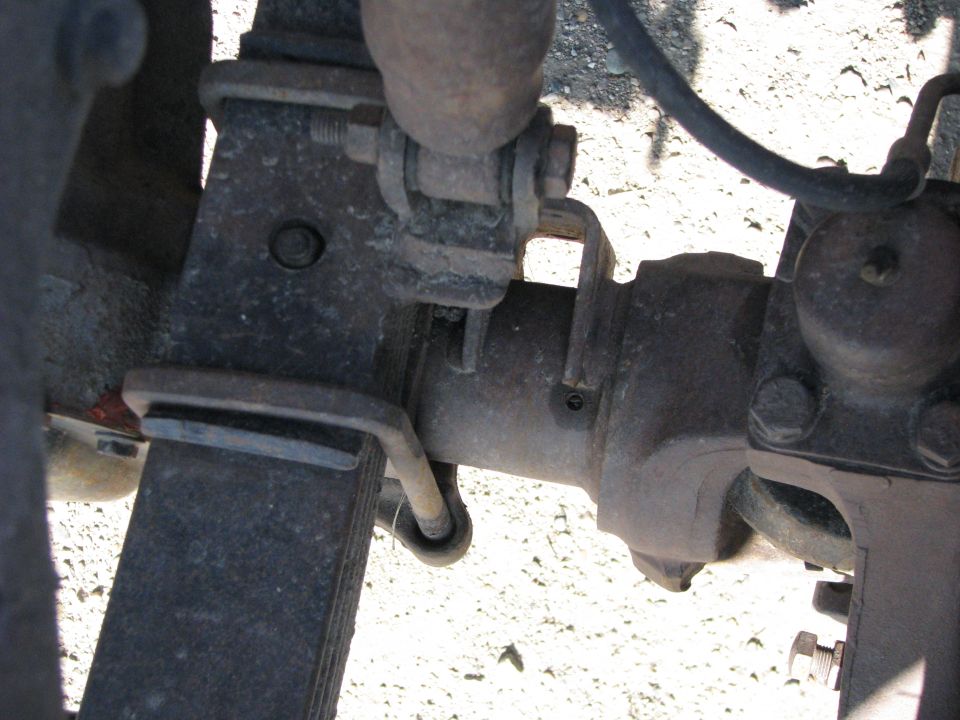 Truck leaf spring and axle assembly, showing rust and wear. The Supermotors.net logo is visible