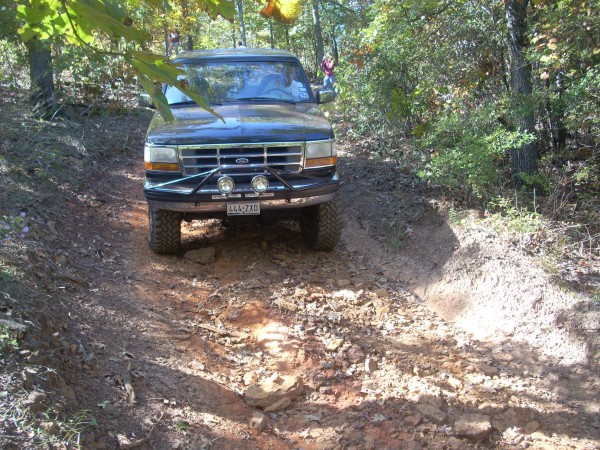 Black 1992 Ford Bronco driving on a dirt trail