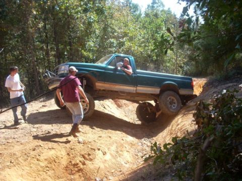1992 Ford Bronco - Pickup truck attempts to climb a challenging off-road trail with assistance from bystanders.
