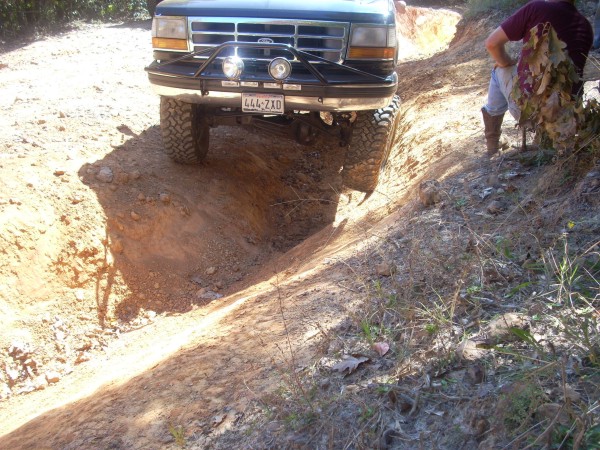 Ford F-Series truck going off-road, front bumper and grille visible. License plate 444-ZXD