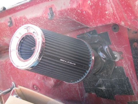 1983 Ford F-250 - A Spectre air filter is mounted in the fender well of a red vehicle.