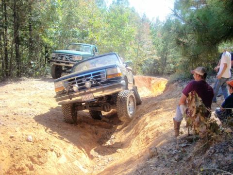 1992 Ford Bronco - This 1992 Ford Bronco tackles a challenging off-road course, with a second truck visible in the background.