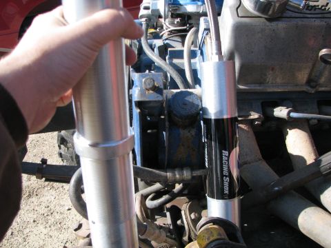 1983 Ford F-250 - Close-up of an engine bay, highlighting new racing shocks being installed. The 'Ford' badge is visible on the engine block.