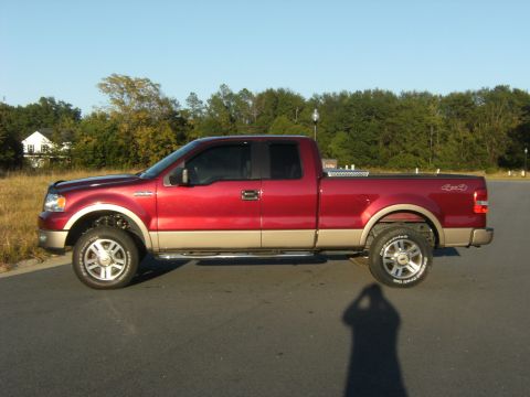 2005 Ford F-150 - This 2005 Ford F-150 pickup truck is shown from the side, a two-tone red and tan paint scheme and a leveling kit.
