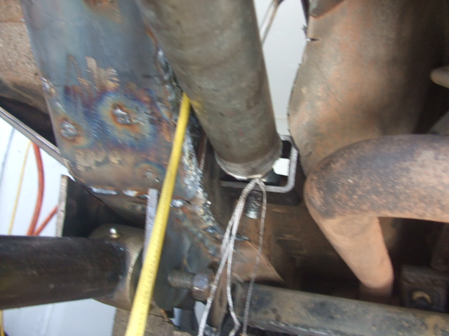 close-up of vehicle frame with welding marks and exhaust pipe