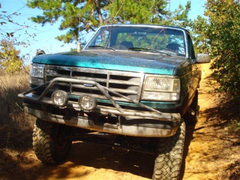 2008 International School Bus - Front view of a modified green pickup truck on a dirt trail.