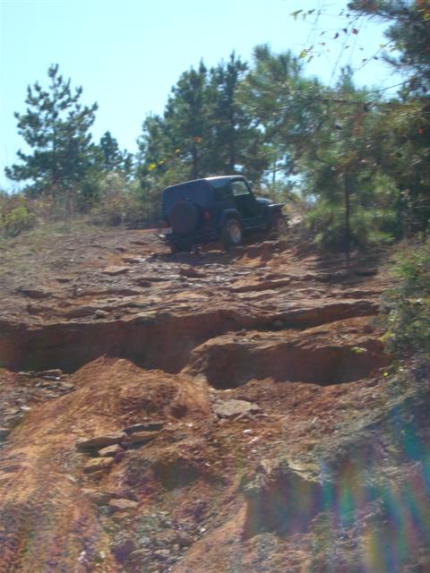 2008 International School Bus - A Jeep navigates a challenging off-road trail on a sunny day.