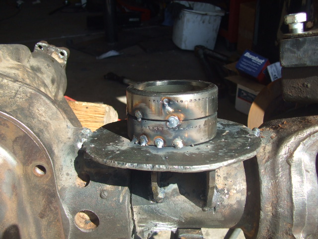 Welded metal ring on vehicle axle housing with visible text