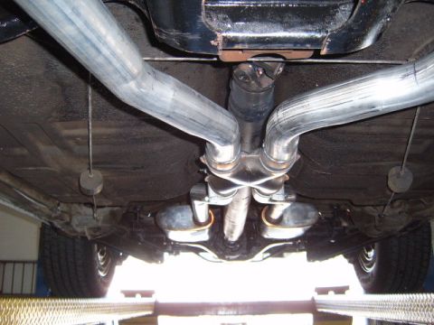 1973 Ford Ranchero - The undercarriage of a vehicle is visible, a dual exhaust system and suspension components.